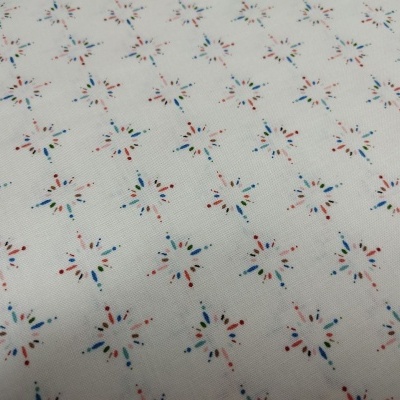 Tecido branco com padrão de estrelas coloridas pequenas