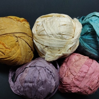 Cinco rolos de fita de tecido colorida sobre fundo preto