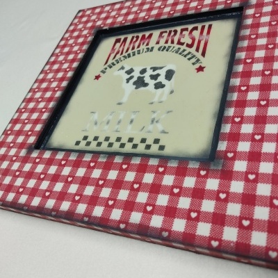 Moldura quadrada vermelha e branca com imagem de vaca e texto