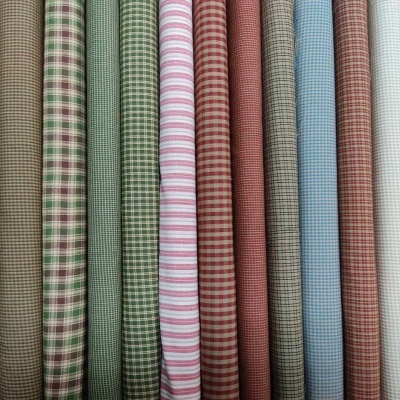 Rolos de tecido xadrez e riscado em várias cores alinhados
