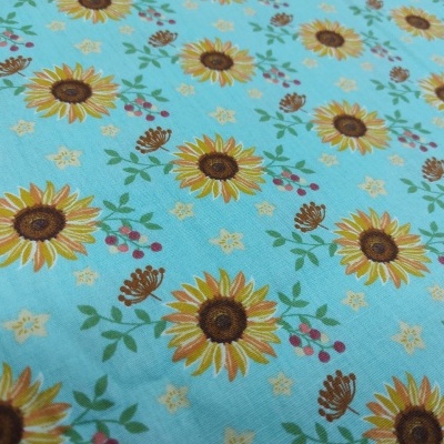 Tecido azul com padrão de girassóis e frutos vermelhos