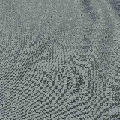 Tecido cinza com padrão pequeno e repetido de figuras pretas e brancas