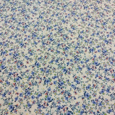 Tecido branco com padrão floral azul, roxo e rosa