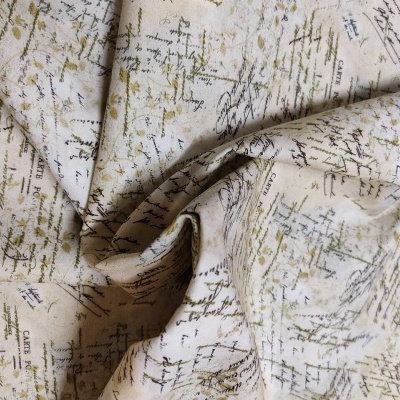 tecido bege com padrão de texto manuscrito em várias cores