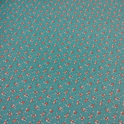 Tecido verde-azulado com padrão repetitivo de pequenas flores vermelhas e brancas