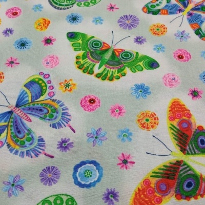 Tecido com padrão colorido de borboletas e flores sobre fundo branco