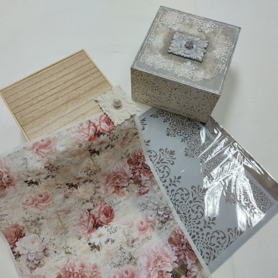 Caixas decorativas em madeira com tecido floral e caixa prateada sobre superfície branca