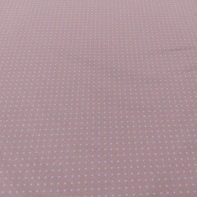 tecido cor-de-rosa com pequenos pontos brancos em padrão regular
