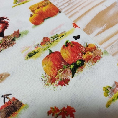 Pano de cozinha branco com estampado colorido de abóboras e cenas rurais