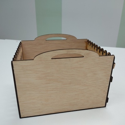 Caixa organizadora de madeira clara com pega oval em mesa branca