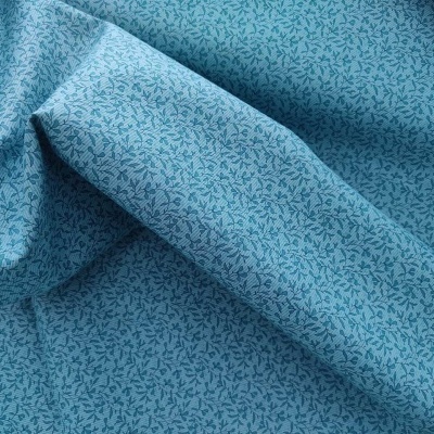 Tecido azul claro com padrão de folhas pequenas azuis escuras
