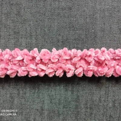 Faixa decorativa rosa com flores sobre tecido cinza