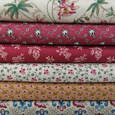 Tecidos empilhados com padrões florais coloridos em várias cores.