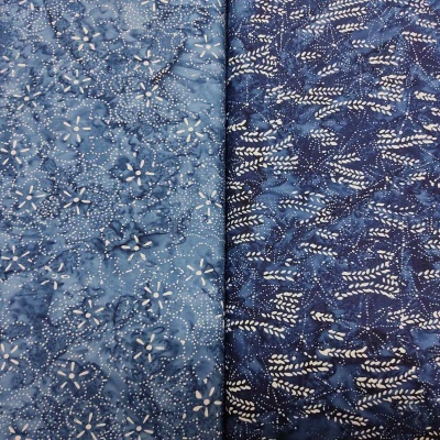 Dois tecidos batik azuis com padrões florais e lineares brancos