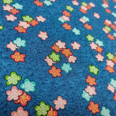 Tecido azul com flores pequenas coloridas e detalhes em linhas pretas