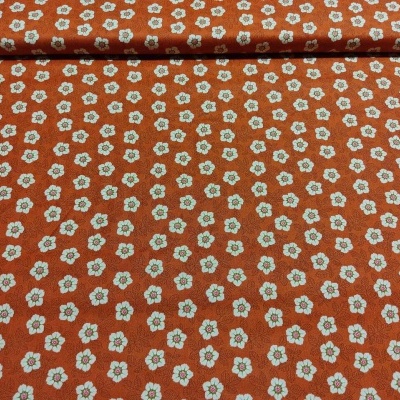 tecido castanho alaranjado com pequenas flores brancas e verdes
