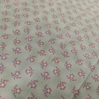 Tecido floral verde claro com pequenas flores rosa e amarelas