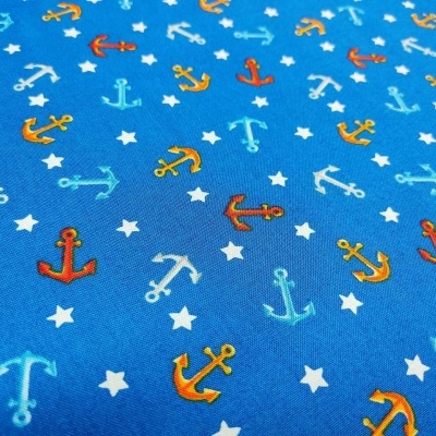 Tecido azul com âncoras coloridas e estrelas brancas