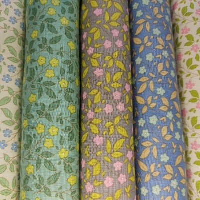 Cinco rolos de tecido com padrões florais coloridos