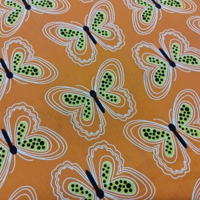 Tecido laranja com padrão de borboletas verdes e pretas