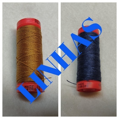 Dois carretéis de linha castanha e azul escura com extremidades vermelhas