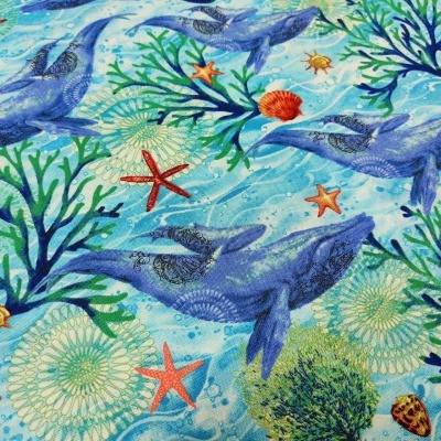 Tecido azul com baleias, estrelas-do-mar, conchas e algas verdes
