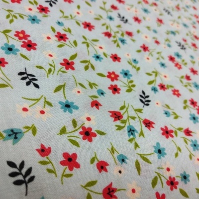 Tecido branco com pequenas flores coloridas e padrão floral