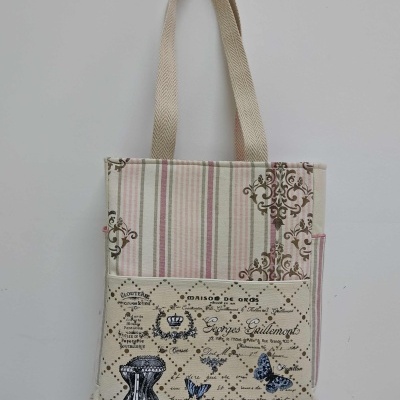 Sacola de tecido com padrão de riscas e ilustrações de mariposas e frasco de perfume