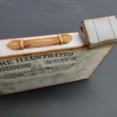 Caixa decorativa vintage com pega castanha e texto THE ILLUSTRATED LONDON NEWS