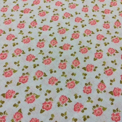 Tecido branco com padrão de flores rosas e folhas verdes