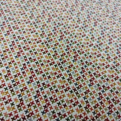 Tecido com padrão de pequenos X coloridos sobre fundo branco
