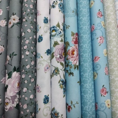 Tecidos com padrões florais e lisos em várias cores pastel