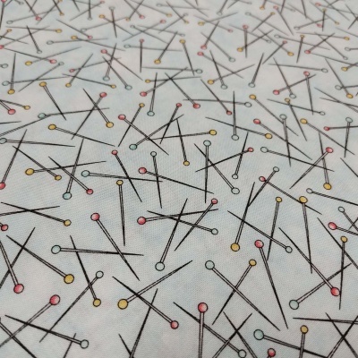 Tecido branco com padrão de alfinetes coloridos em tons pastel