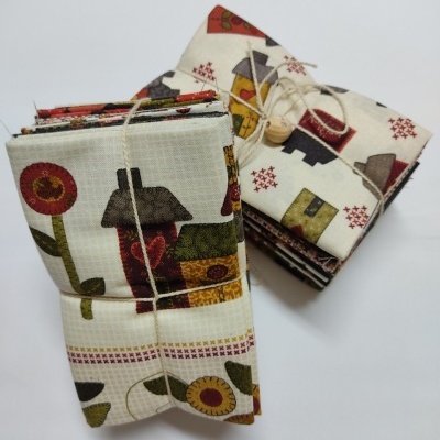 Tecidos com padrão de casas e flores, dobrados e amarrados com corda