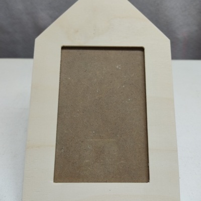 Moldura de madeira clara em formato de casa com espaço para fotografia