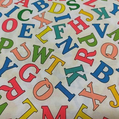 Tecido branco com letras coloridas do alfabeto em maiúsculas