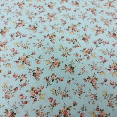 Tecido azul claro com padrão floral cor-de-rosa e verde