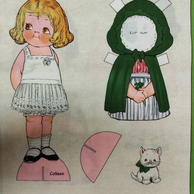 Pano impresso com boneca Colleen e roupa destacável e um gato branco.