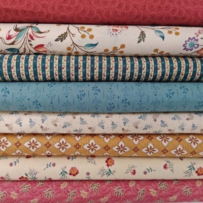 Pilhas de tecidos coloridos com padrões florais e riscas