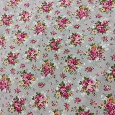Tecido com padrão floral em fundo cinza com flores rosas e vermelhas.