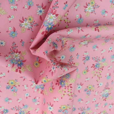 Tecido rosa com padrão floral colorido e textura visível
