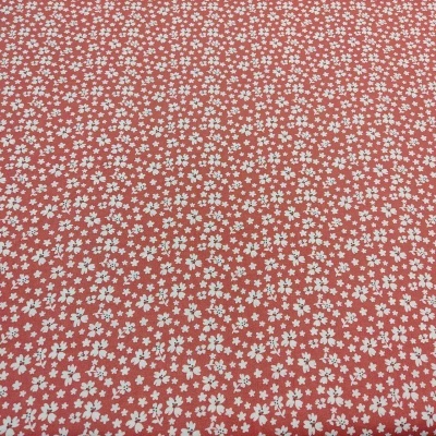 Tecido com padrão de pequenas flores brancas sobre fundo cor de tijolo