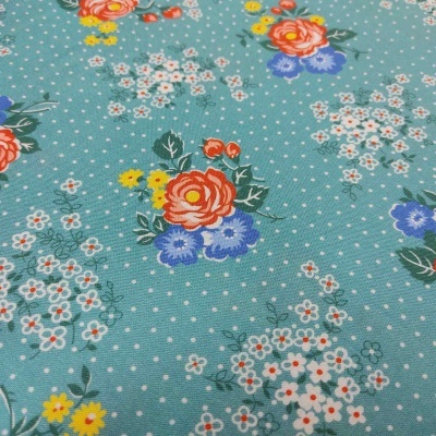 Tecido azul claro com padrão floral colorido e pontilhado branco