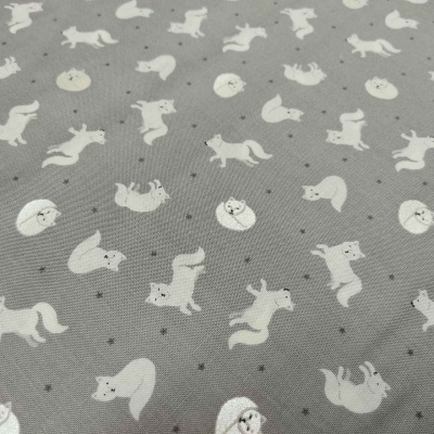 Tecido cinzento com padrão de raposas brancas e estrelas pequenas.