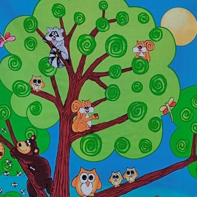 Tecido colorido com desenhos de animais numa árvore e céu azul