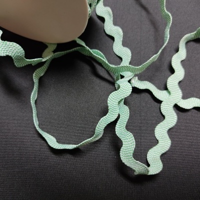 Fita decorativa verde claro ondulada sobre fundo preto