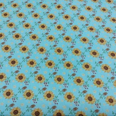 Tecido azul claro com padrão de girassóis amarelos e folhas verdes
