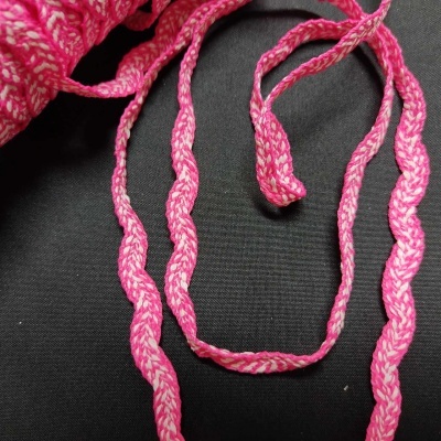 Cordão trançado cor-de-rosa e branco sobre fundo preto