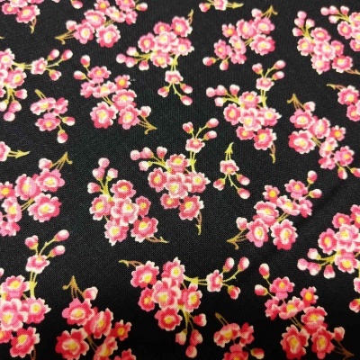 Tecido preto com padrão floral cor-de-rosa e amarelo