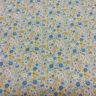 Pano com padrão floral azul, amarelo e verde sobre fundo branco